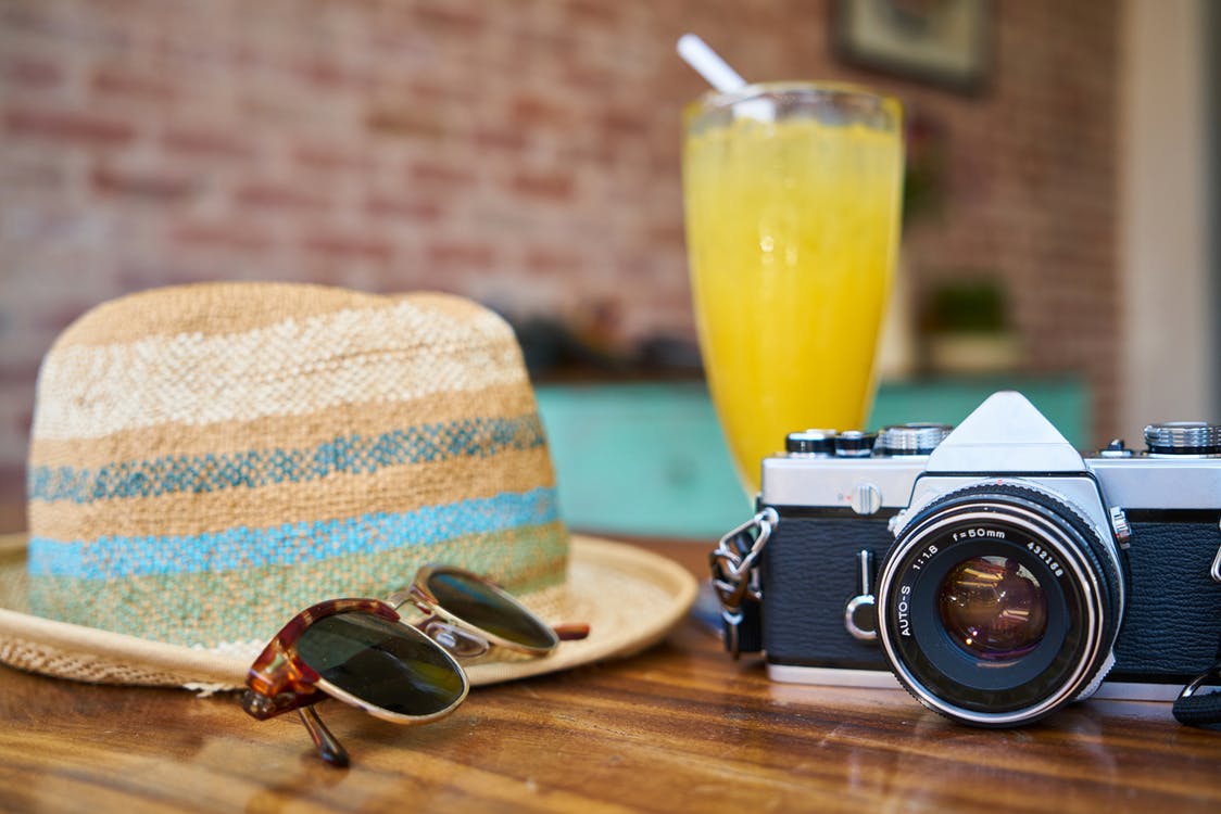 Sommerhut, Fotoapparat und Limonadenglas