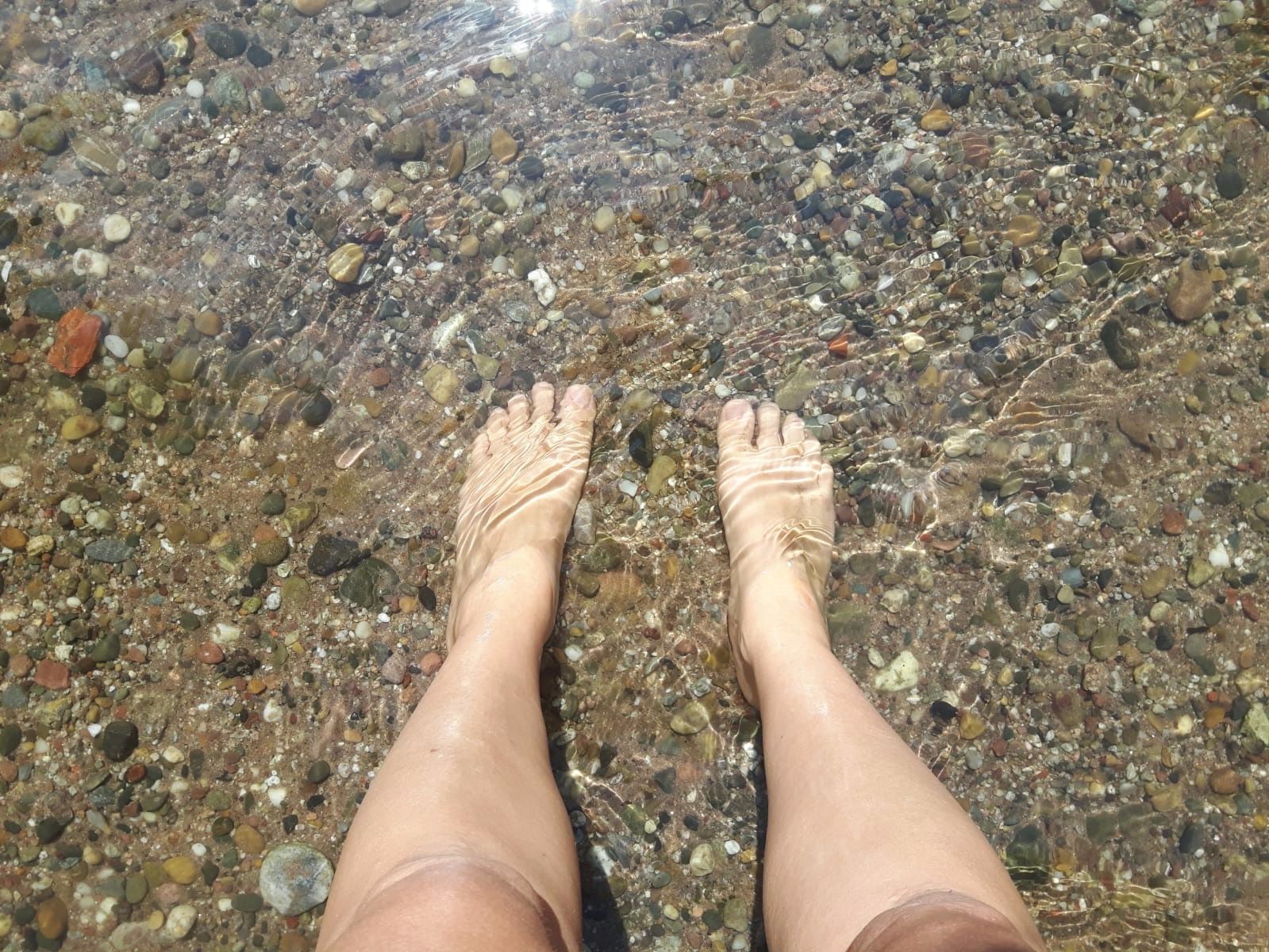 Ein paar Füße im klaren Flusswasser