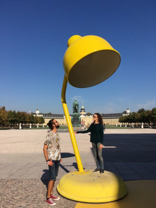 Josh und Francesca auf einer großen Schreibtischlampe als Kunstinstallation