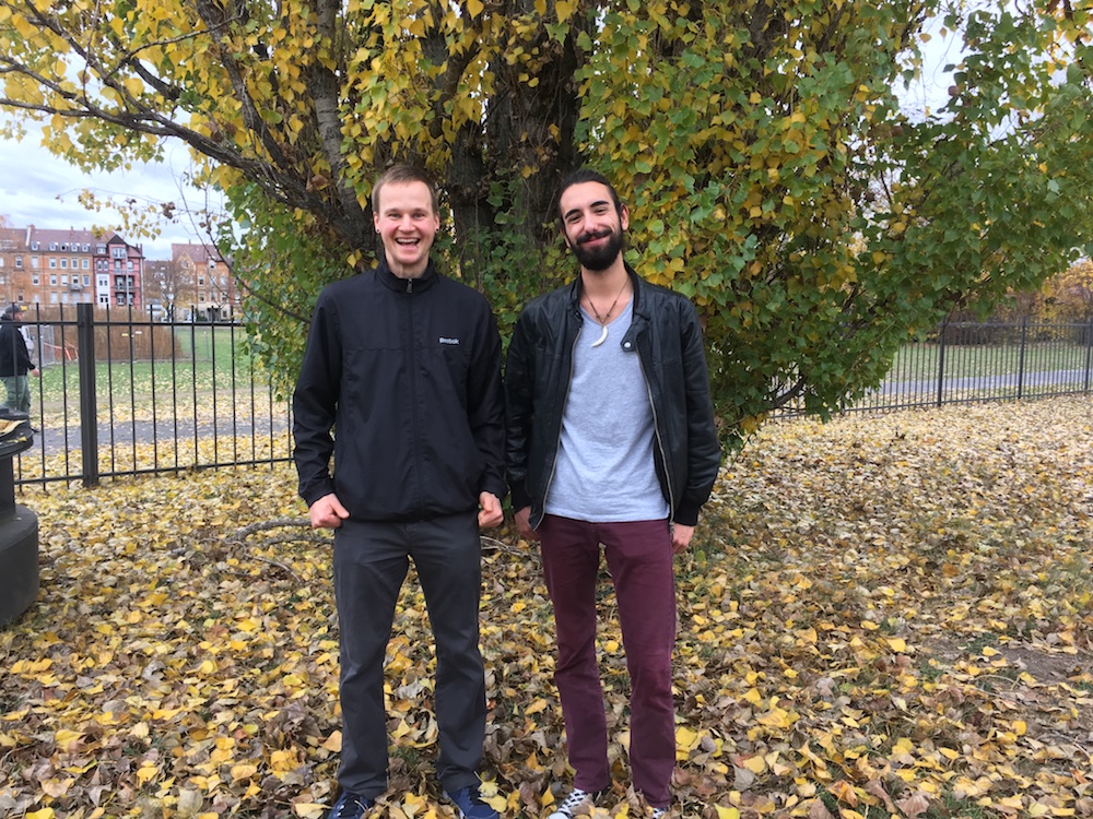 Moderatoren Josh und Steffen auf einer Wiese mit Herbstlaub