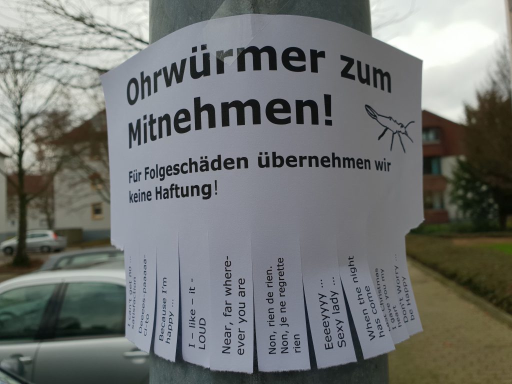 Zettel an einem Laternenpfahl "Ohrwürmer zum Mitnehmen"