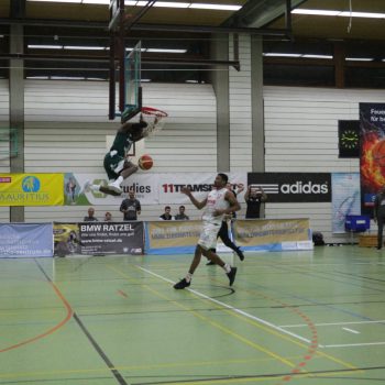 Spieler beim Basketballspiel springt an den Korb