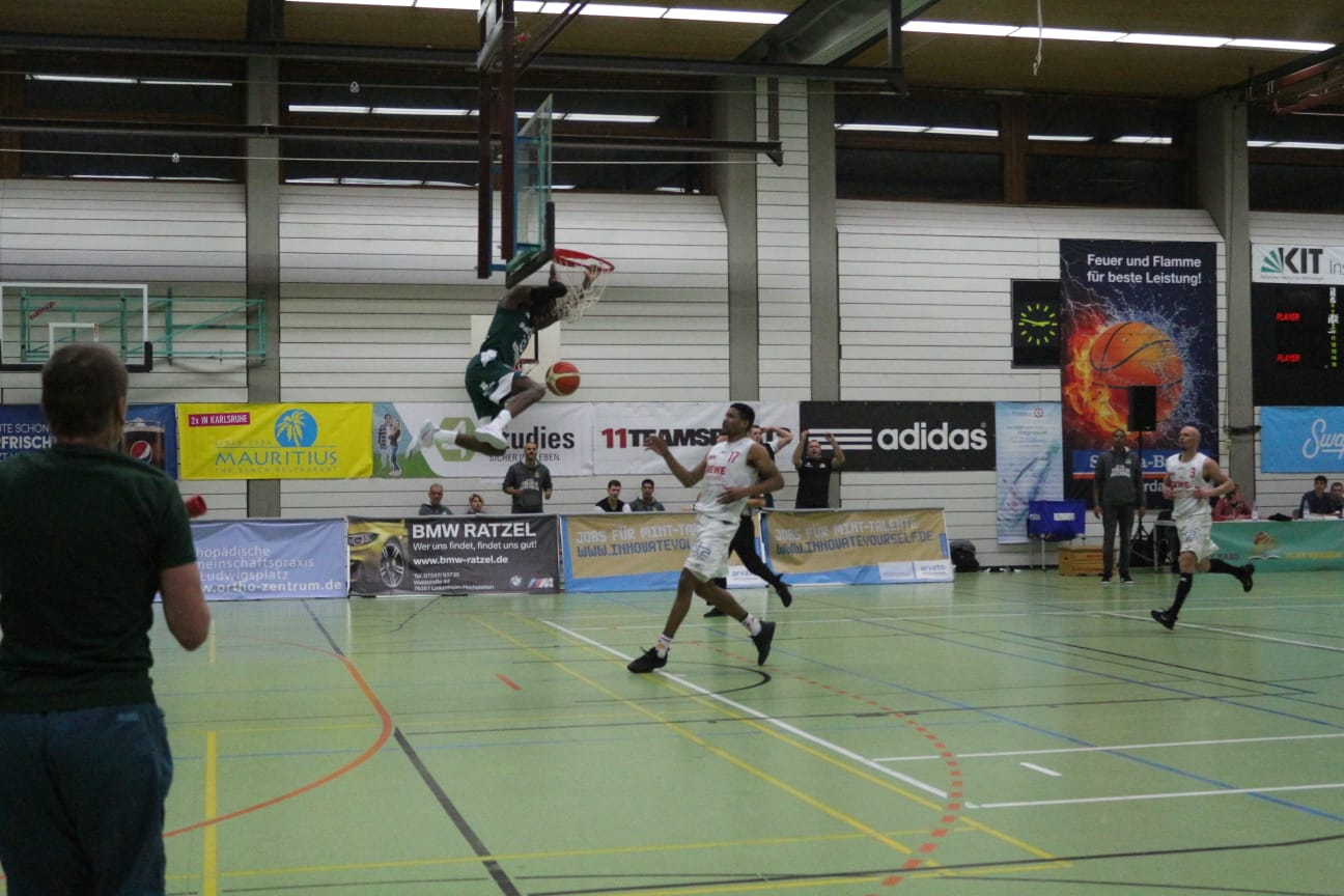 Spieler beim Basketballspiel springt an den Korb