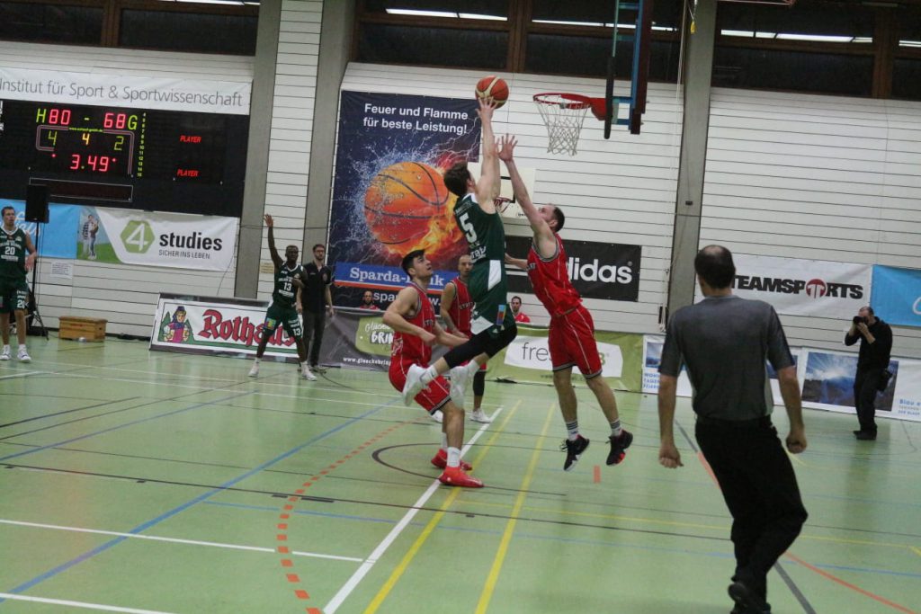 Gegnerische Basketballspieler auf dem Spielfeld in der Halle