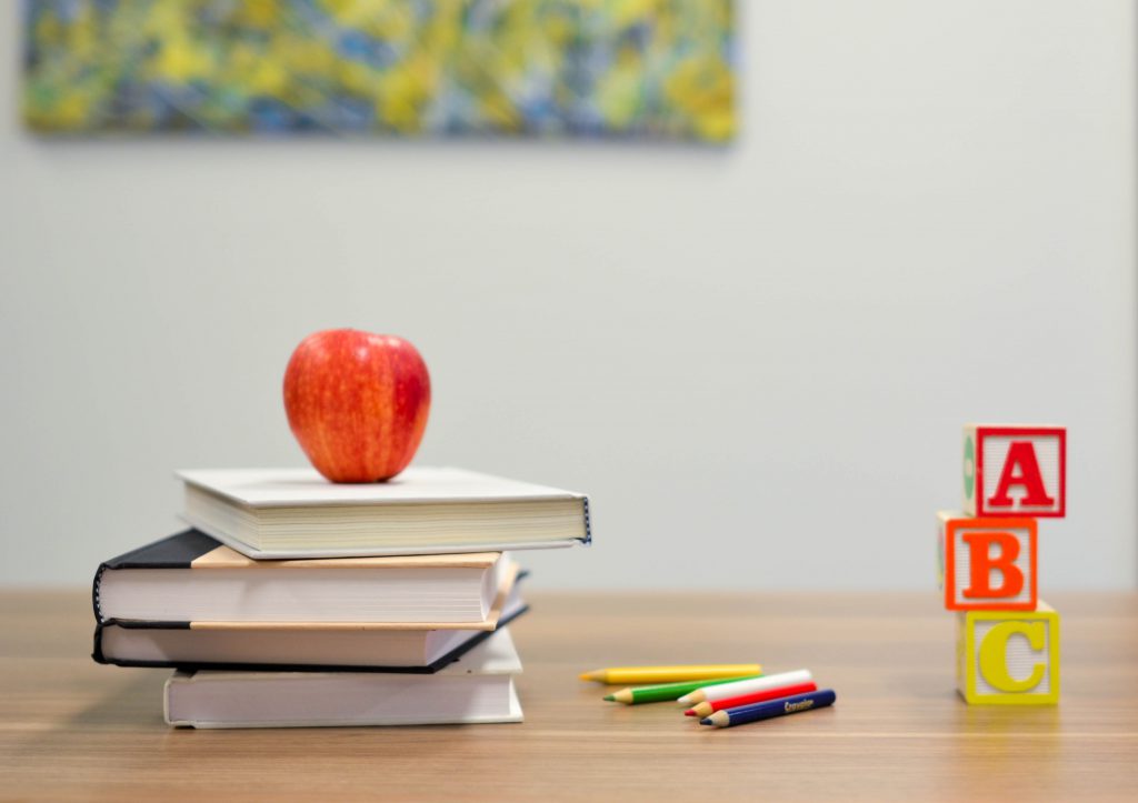 Tischplatte mit Bücher, Apfeö, Stiften und Bauklötzen