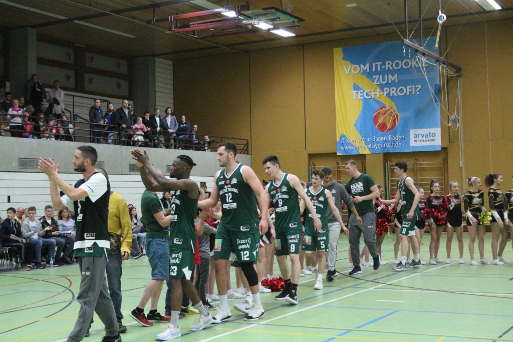 KIT-Basketballteam läuft aus der Halle und winkt ins Publikum