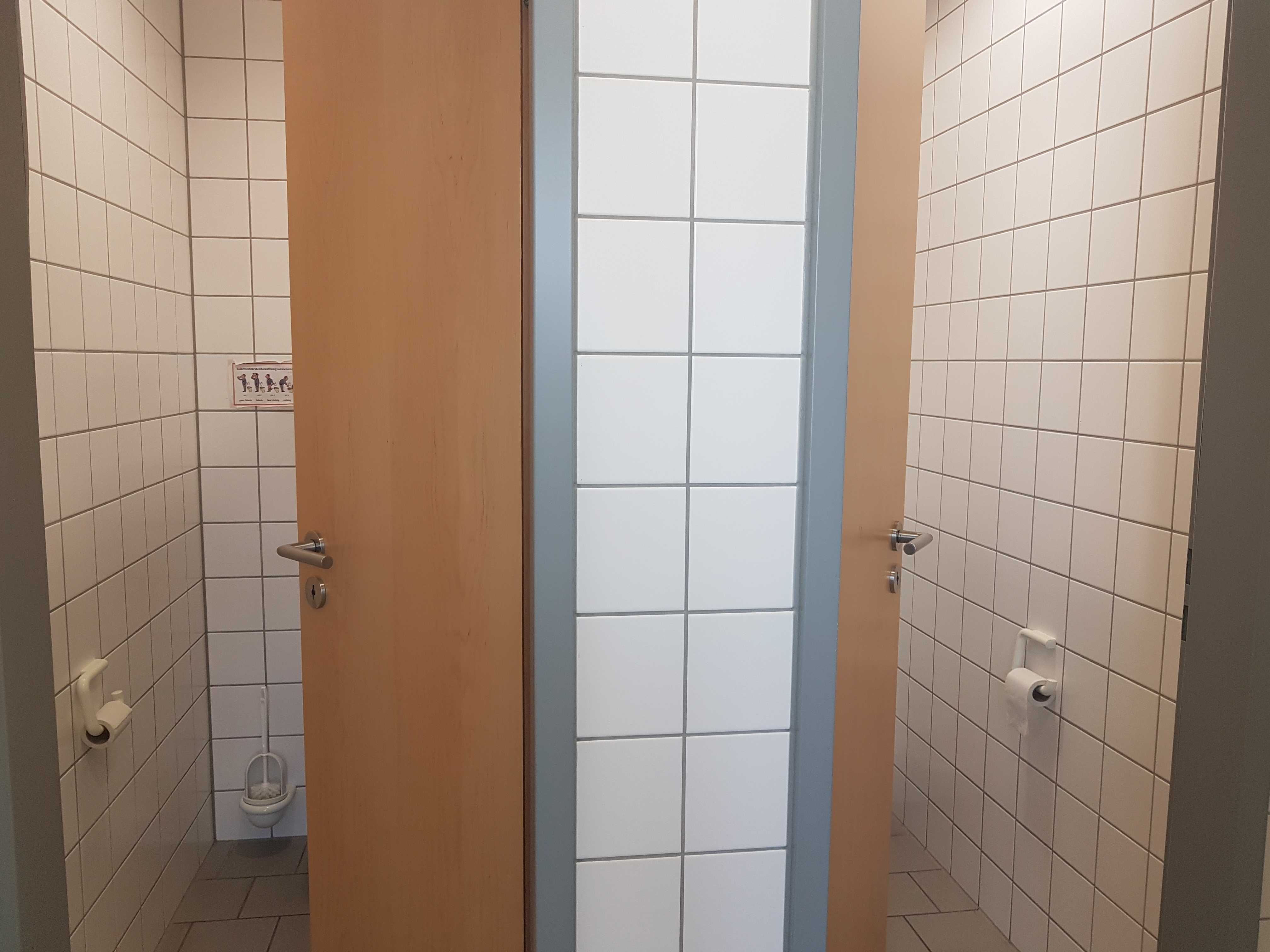 Blick auf zwei geöffnete Toilettentüren