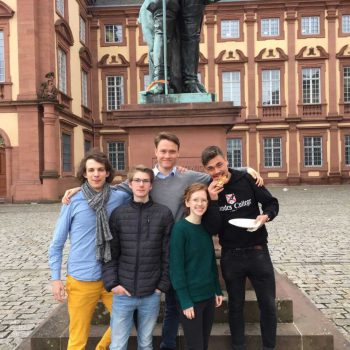 Fünf junge Erwachsene vor einer Schlosskulisse