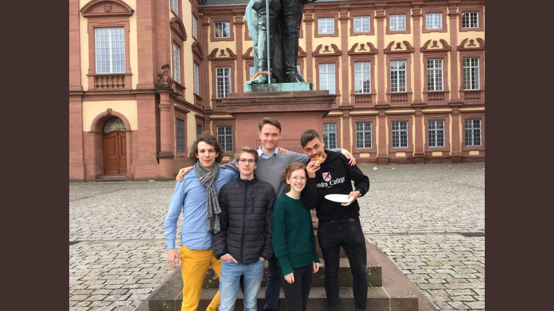 Fünf junge Erwachsene vor einer Schlosskulisse