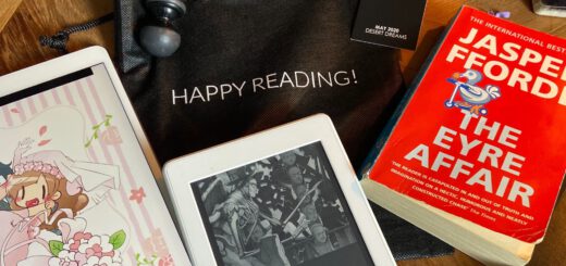 Tisch mit Büchern, E-Book-Reader und Kaffeetasse